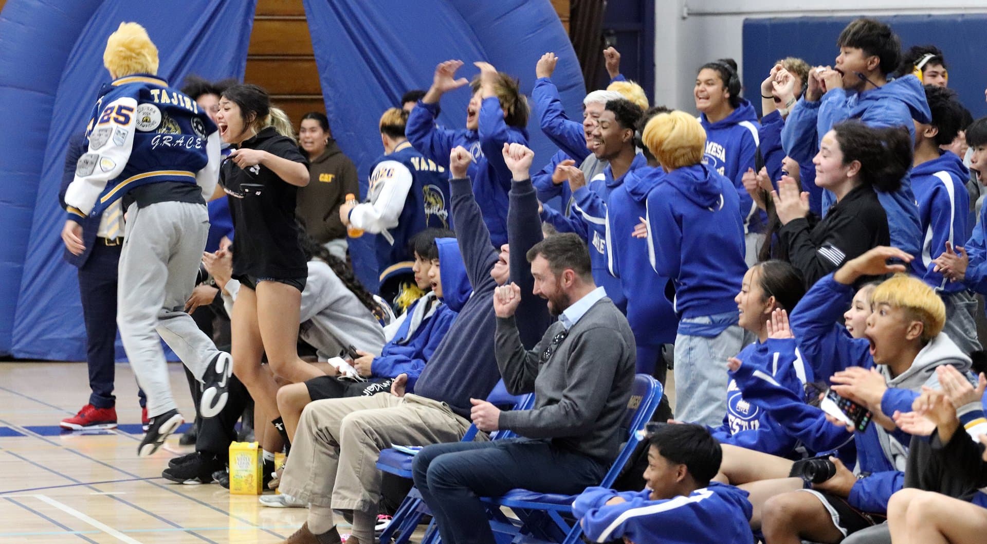 Mira Mesa team going wild on the bench during the 2025 dual meet vs San Diego — a wrestler walking off after a win